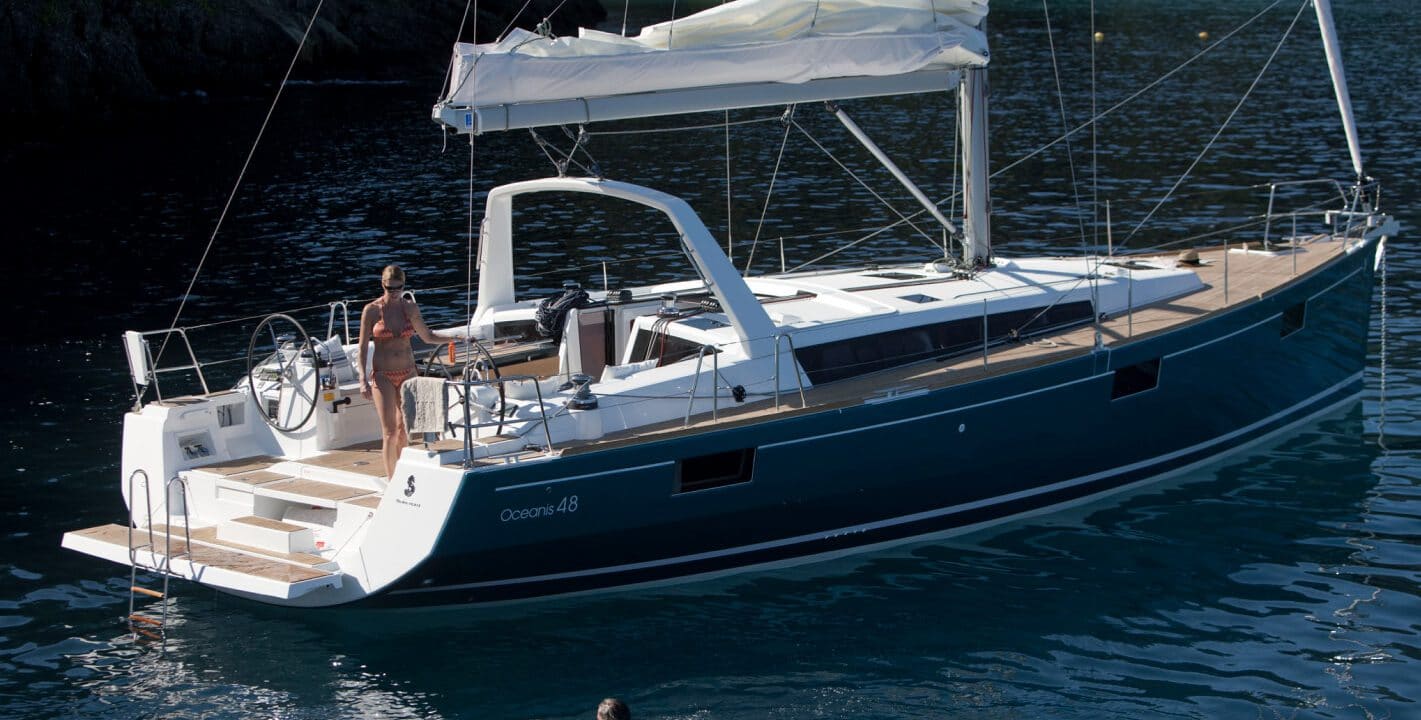 Beneteau Oceanis 48 yacht sailing on the lake with mountains in the background