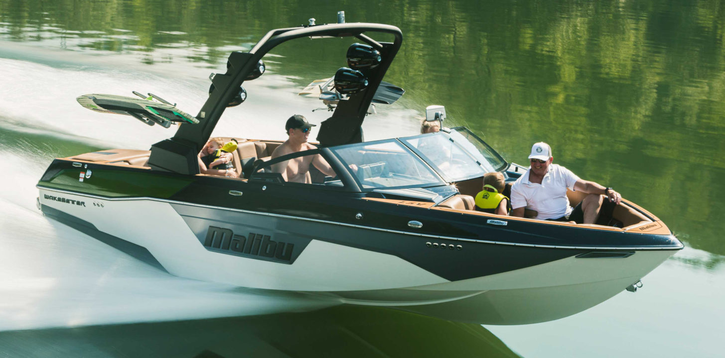 Malibu motor boat on the water with mountains in the background